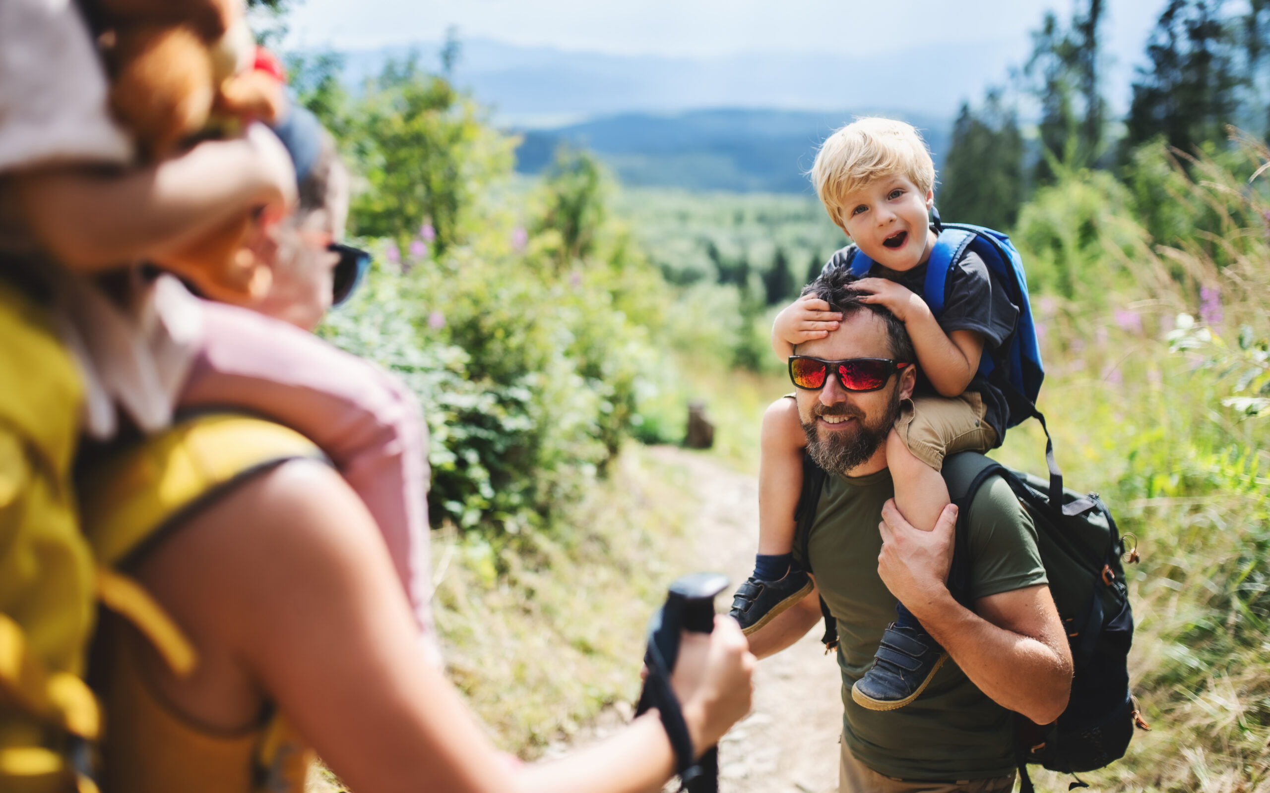 Man hiking with his family in the mountains representing healthy testosterone levels, prostate health, and an active lifestyle.