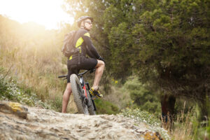Man mountain biking on a rugged trail, symbolizing fast recovery and enhanced healing performance with BPC-157 therapy at Axios Health and Wellness