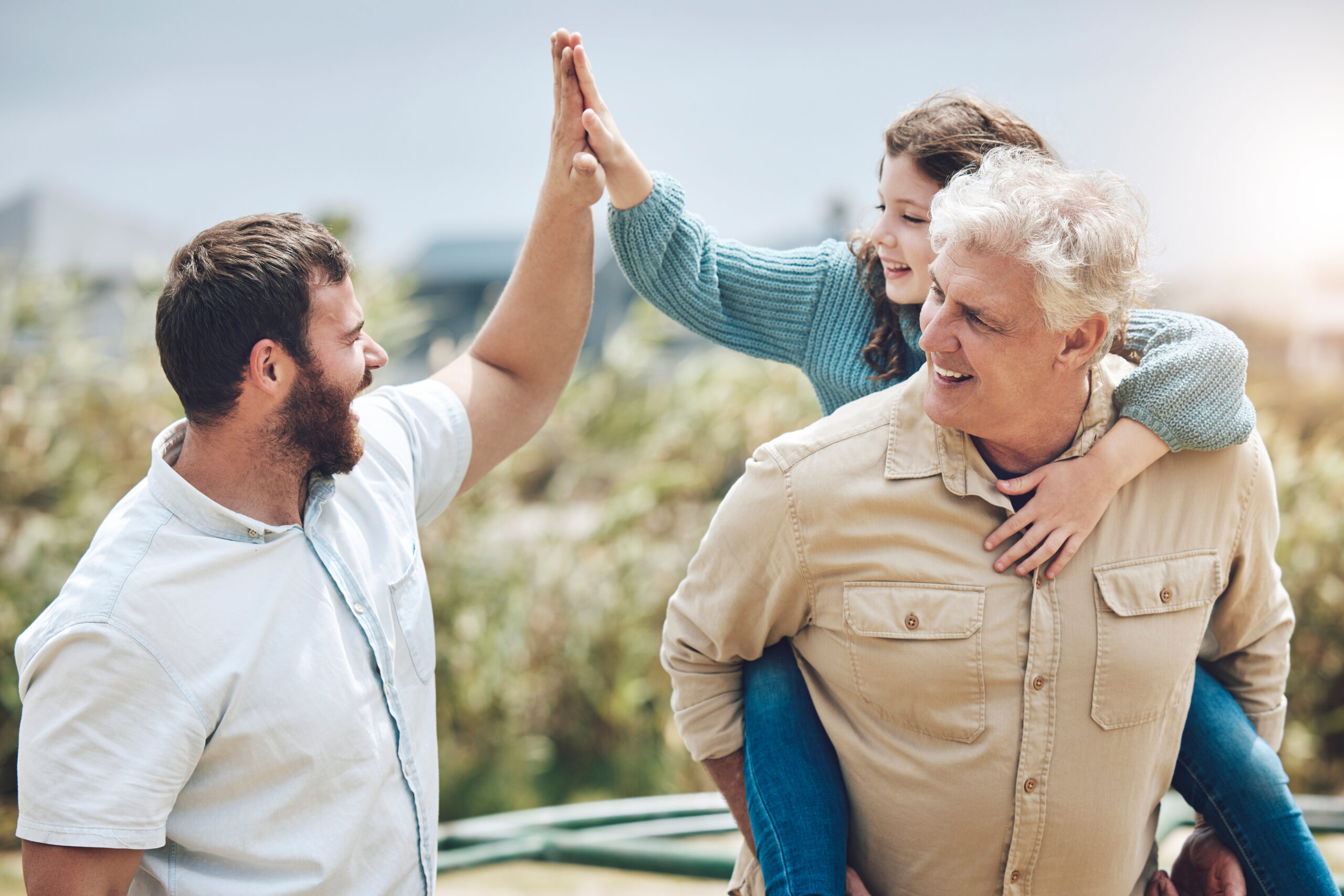Father high-fiving his daughter while spending time with family, representing energy and vitality supported by healthy testosterone levels.